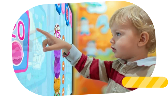 Child interacting with an educational game on a touch screen, designed for early childhood (3–5 years).